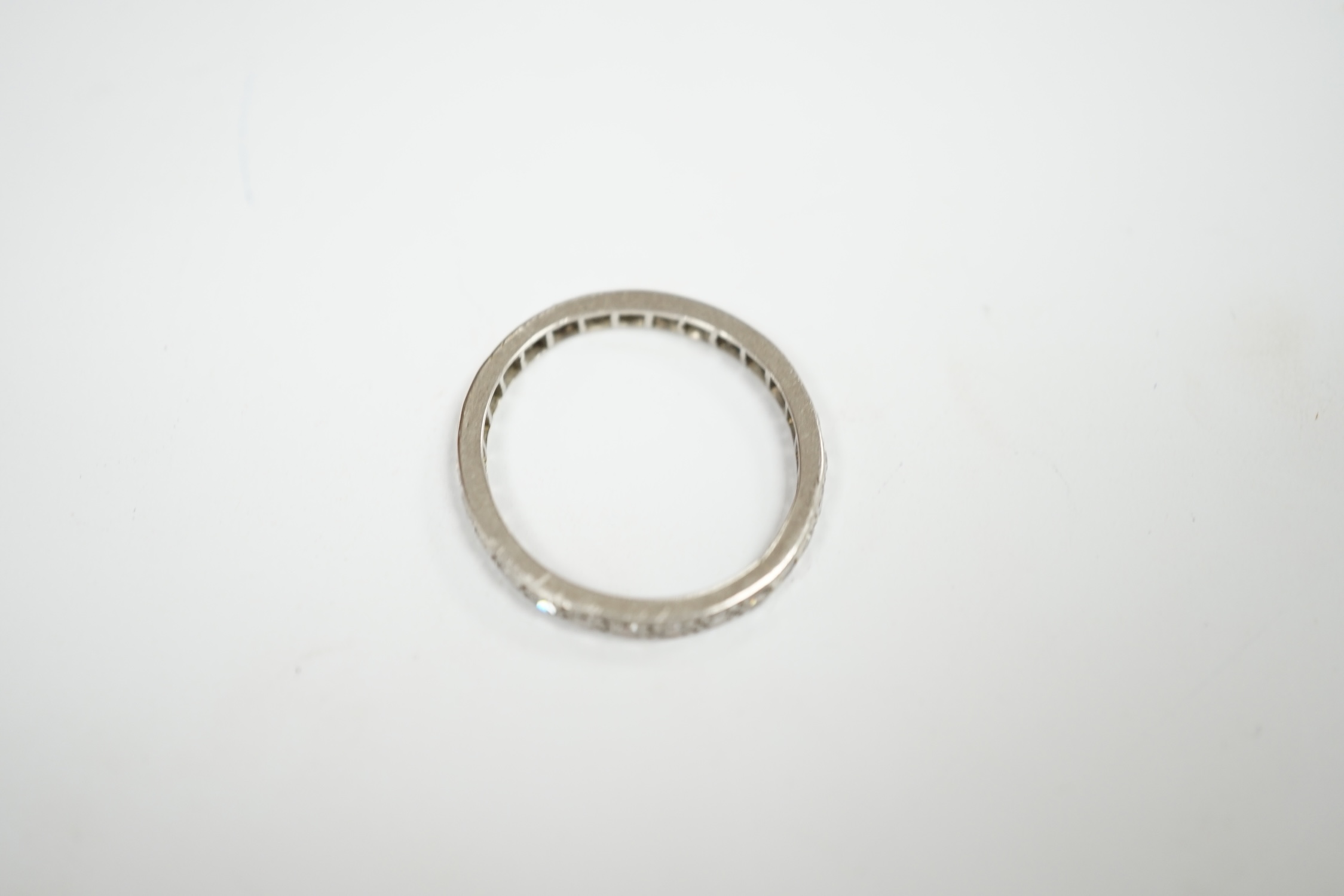 A white metal and diamond set full eternity ring, size P, gross weight 2.6 grams. Condition - fair